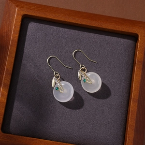 Detailed macro view of Chinese style earrings with pearl tassels and jade-like charms