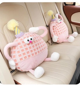 Close-up of cute pink monster lamb wool car headrests on a cream leather seat