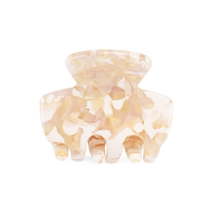 Detailed close-up of a mini acetate hair claw with orange marble patterns on white