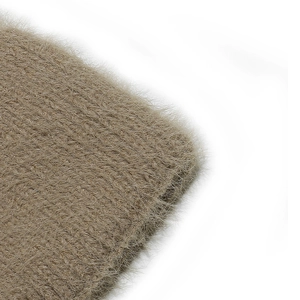 Macro detail of brown chunky knit hat showing soft faux fur texture and fuzzy yarn finish