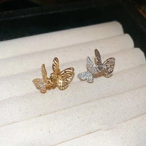 Elegant zircon butterfly ear clips in gold and silver finish on velvet display