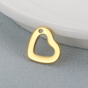 Polished gold stainless steel hollow heart pendant necklace charm on textured surface