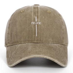 Close-up of white PEACE embroidery and cross on washed cotton khaki baseball cap