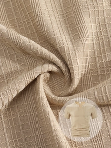 Close-up of light beige men's V-neck knit shirt showing vertical stripe texture and pocket