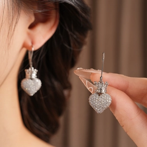 Détail de boucles d'oreilles cœur couronne en argent avec zircons sur un mannequin