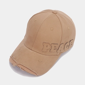 Detail of khaki baseball cap featuring distressed brim and PEACE embroidered patch