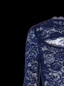 Detail van donkerblauw kantstiksel en ingewikkeld hol ontwerp op de schouder en halslijn