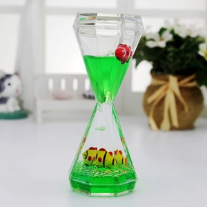 Diamond-shaped liquid hourglass with floating fish models in a green acrylic fluid