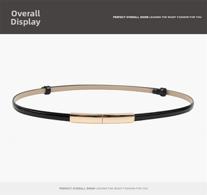 Detail of slim black patent leather belt with a minimalist rectangular gold metal buckle