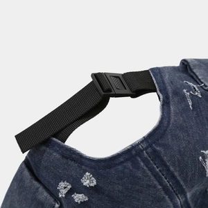 Dettaglio del cinturino in nylon e fibbia sul berretto docker in denim con effetto usato