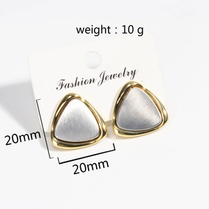 Macro detail of two-tone geometric triangle earrings with brushed silver and gold finish