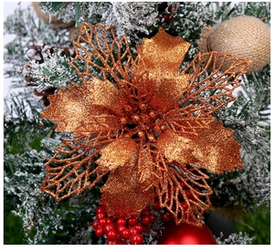 Vue macro d'un poinsettia évidé bronze avec paillettes sur un sapin de Noël décoré
