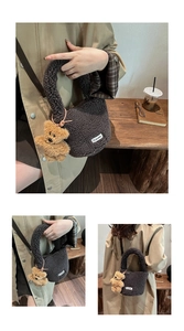 Detail view of dark grey plush tote bag with a cute bear charm and woven label