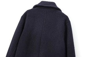 Detail shot of the back collar and textured wool fabric of the double-breasted navy coat