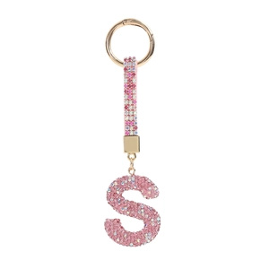 Detail of pink crystal encrusted S-letter keychain with gold metal spring buckle