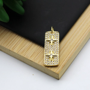 Macro shot of rectangular gold-plated pendant with sparkling zircon and star relief