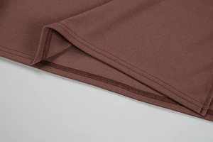 Détail de couture à double aiguille et texture en maille côtelée sur la robe marron