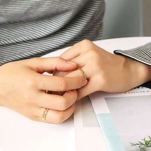 Minimalist gold chain link heart ring set displayed on model hands in a fashion setting