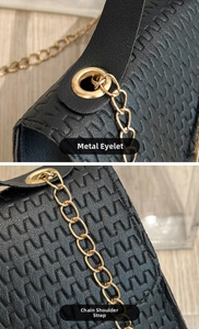 Detalle de bolso negro con textura trenzada, ojales metálicos y correa de cadena dorada