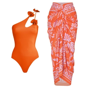 One-shoulder orange swimsuit with floral accents and a matching tropical wrap skirt