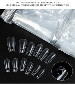 Macro view of clear trapezoid nail tips with skeletonized heart cutout and number details