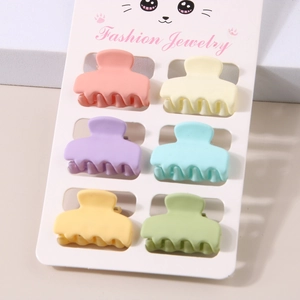 Detailed macro view of six matte macaron-colored mini hair clips on a white display card