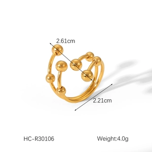 Macro shot of gold layered crossover open ring featuring polished spheres and 4g weight