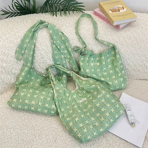 Detail view of green floral print tote bags on a soft fleece texture background
