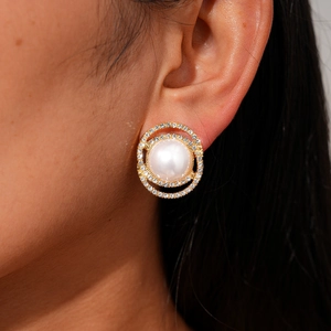 Macro view of double halo pearl stud earrings with sparkling crystals and gold finish