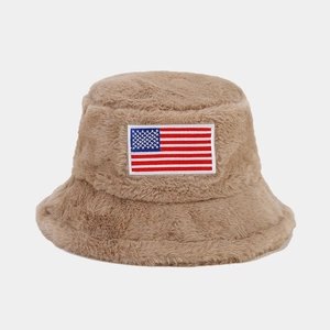 Détail d'un bob en peluche kaki avec un écusson brodé du drapeau américain fin