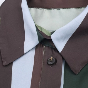 Close-up of lapel collar and buttons on a vertical striped satin texture shirt