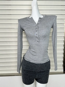 Détail d'un haut Henley gris à manches longues et d'un short en maille texturée
