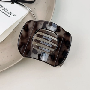 Detailed view of a vintage tortoiseshell hair clip on a minimalist ceramic tray