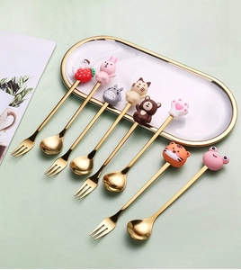 Detailed set of 7 gold stainless steel cutlery with 3D cartoon animal handles on a tray