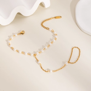 Détail de bracelet de doigt en acier inoxydable doré avec perles sur décor céramique