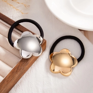Close-up of elegant gold and silver floral metal charms on elastic ponytail holders
