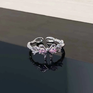 Detailed macro view of pink zircon bow-knot ring with silver twisted rope band