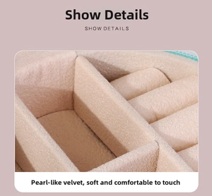 Detail showing beige granular velvet lining and ring slots inside a portable jewelry box