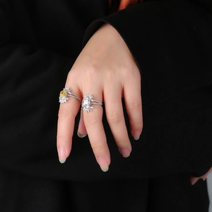 Close-up of S925 silver ring featuring pear and square cut diamonds on model's hand
