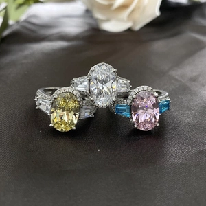 Halo ringen met ovale gele, witte en roze stenen op een donkere fluwelen achtergrond