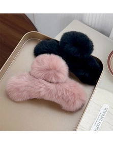 Detailed view of plush faux fur hair claws in pink and black on a gold tray