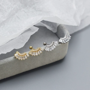 Macro shot of gold and silver fan-shaped S925 silver stud earrings with baguette crystals