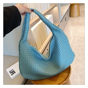 Close-up of light blue woven leather hobo bag featuring classic braided texture