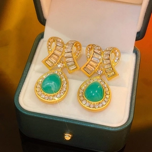 Dettaglio di orecchini vintage dorati con smeraldo verde e diamanti in scatola regalo
