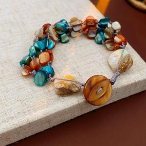 Macro shot of handmade shell bracelet with multi-colored natural shards on linen