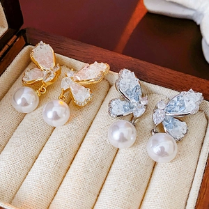Detail view of butterfly drop earrings with colored crystals and white round pearls