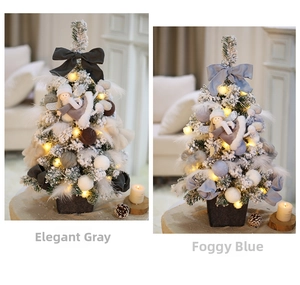 Detailed view of two luxury mini snowy Christmas trees in grey and blue with warm LED lights