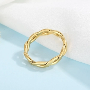 Close-up of golden stainless steel twisted rope ring with elegant metallic luster finish