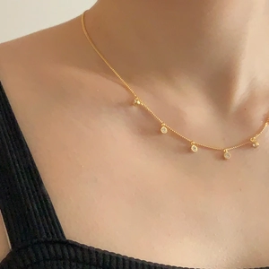 Minimalist 925 sterling silver gold necklace with five zircon pendants on a model