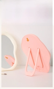 Rear view of pink cloud mirror showing the foldable stand and wall mounting hole details